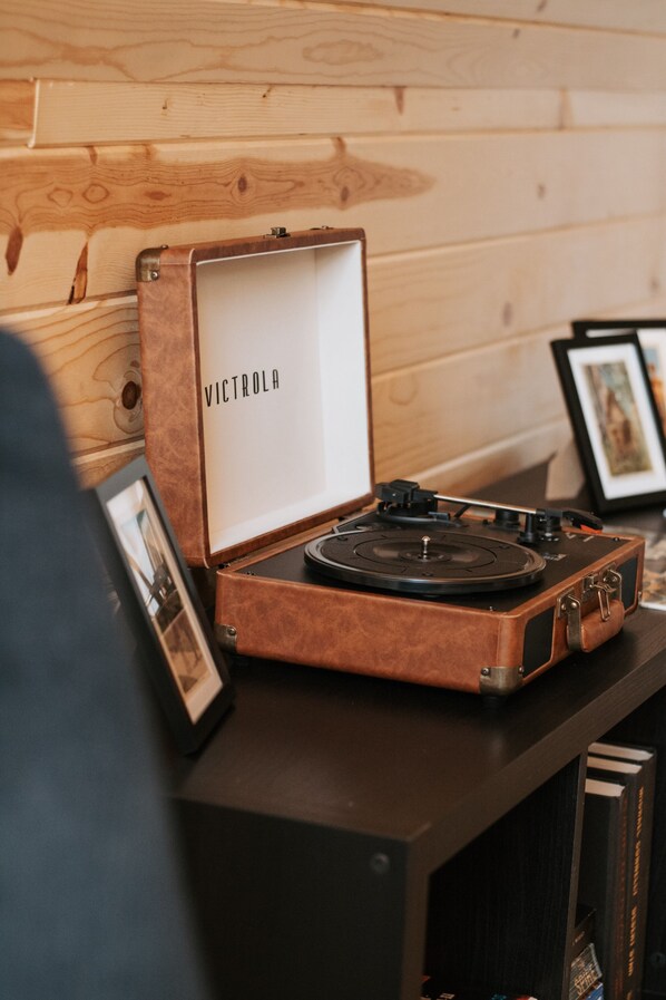 Tocadiscos con carcasa de madera etiquetado 'VICTROLA' sobre una superficie oscura.