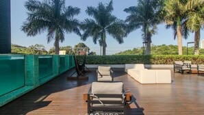 A rooftop pool area with lounge chairs and a view of palm trees. - Beautiful Apartment in Building With Pool Mpb0034 (Itajai)