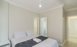 Une chambre à coucher avec un lit, une table de chevet et une armoire.