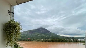 Un balcon avec vue sur une rivière et une montagne.
