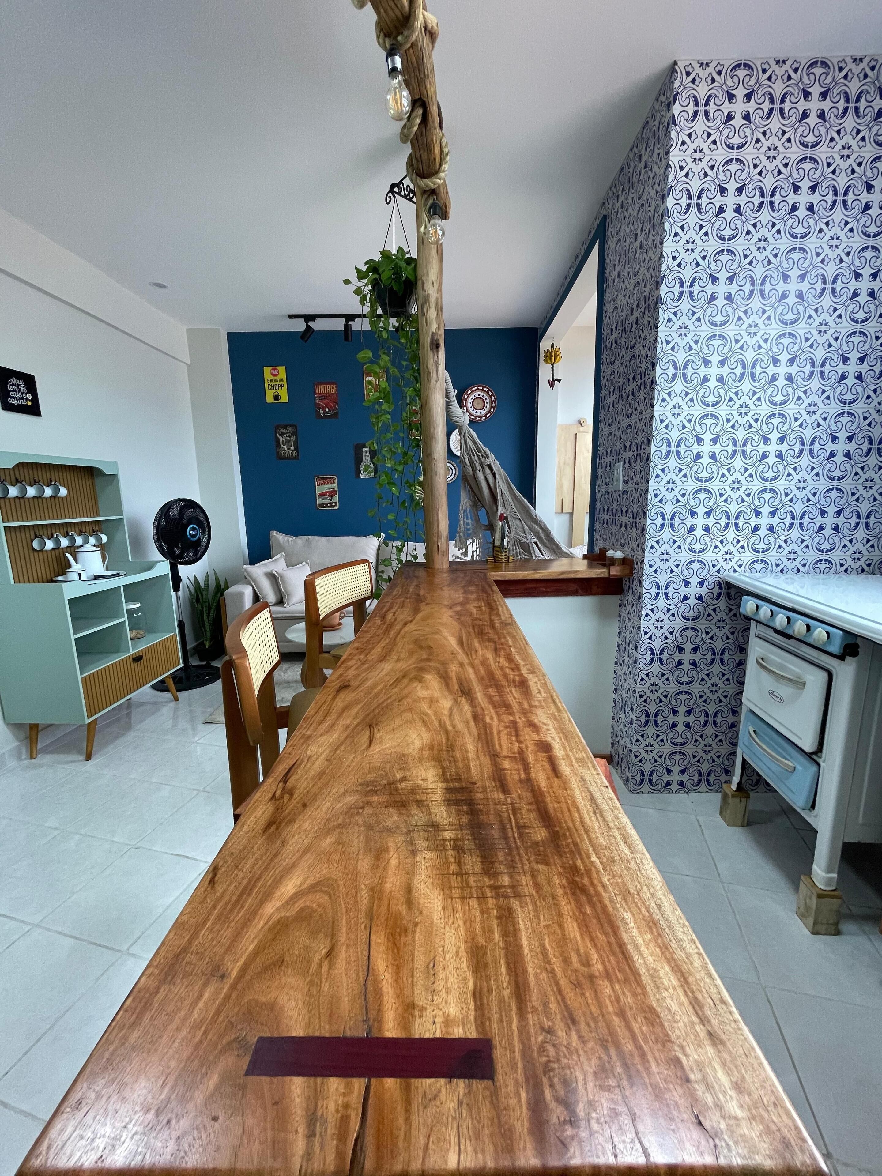 Un ampio soggiorno con un tavolo da pranzo in legno, una parete decorata in blu e un vecchio fornello.