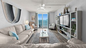 A living room with a sofa, coffee table, and a bookshelf.