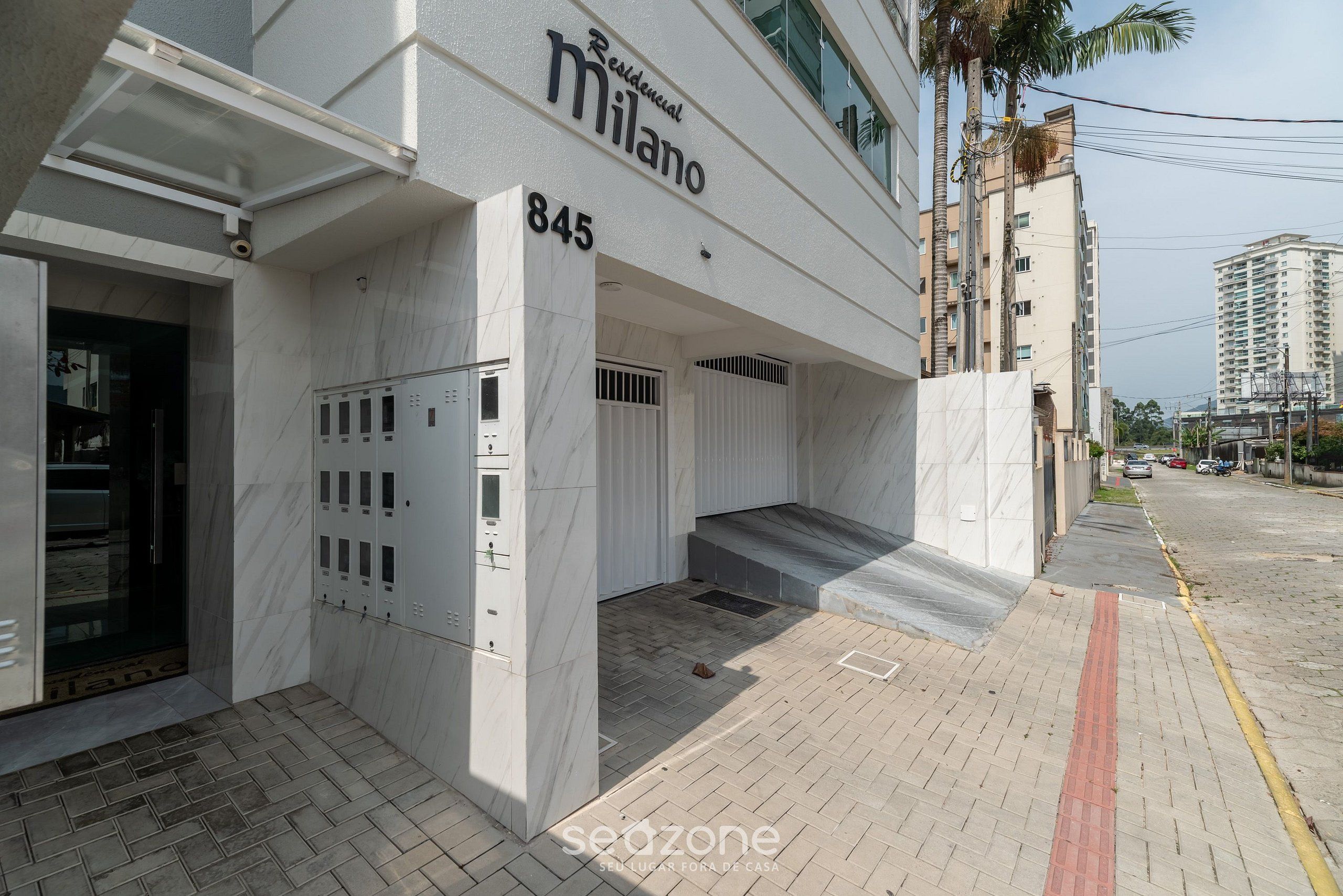 Un immeuble moderne sur lequel on peut lire l’inscription : « Milano 845, résidence ».
