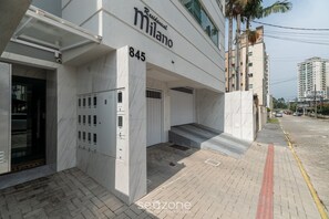 A modern building with a sign reading "Milano 845 Residential." - 2BR Apt With BBQ in Meia Praia Mlo0601 (Itapema)