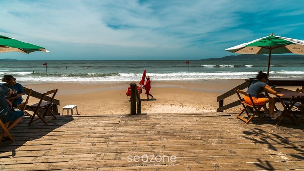 A wooden deck with beach chairs and umbrellas overlooking the ocean. - 2BR Apt With BBQ in Meia Praia Mlo0601 (Itapema)