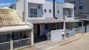 A modern residential building with a flat roof, a covered patio area, and a small outdoor seating space. - Casa 2Q c/ churrasq. 600m orla MCA0609 (Picarras)