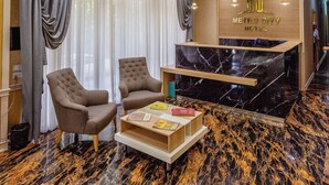 A modern hotel lobby with a marble floor, a reception desk, and a chandelier. - METRO CITY HOTEL (Baku)