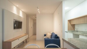 Una sala de estar moderna con televisor, sofá y comedor.