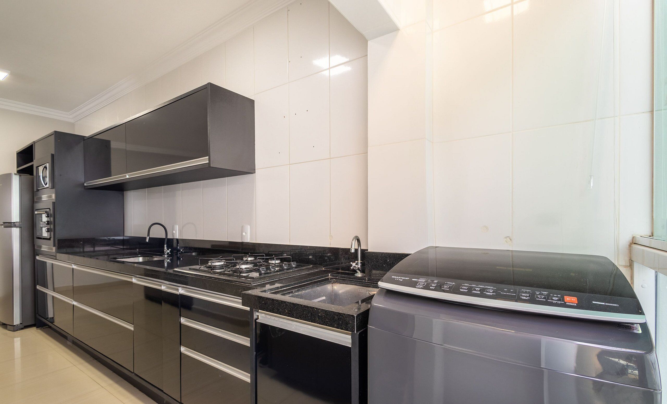 Una cocina moderna con electrodomésticos de acero inoxidable, horno integrado y microondas.