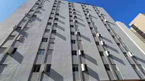 A tall, modern building with a grid of windows and balconies. - Studio Cambuí 67 - Community Center (Campinas)
