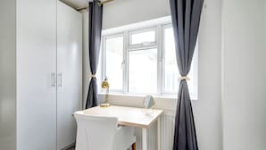 A small, neatly arranged room with a white desk, chair, and a window with curtains. - 2 Bedroom flat in Putney by the river (London)