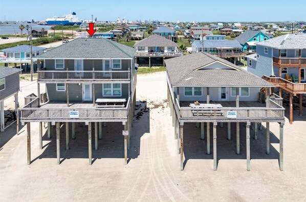 Il s'agit d'une propriété située en bord de mer, avec des bâtiments à deux étages, chacun doté d'un balcon et d'une enseigne indiquant qu'il se trouve au bord de la plage.