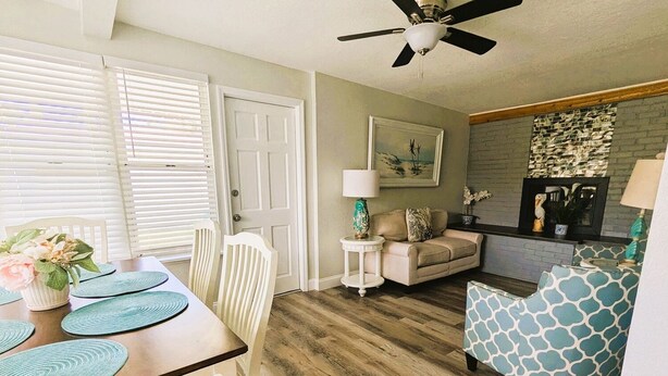 A dining area with a wooden table, chairs, and a ceiling fan.