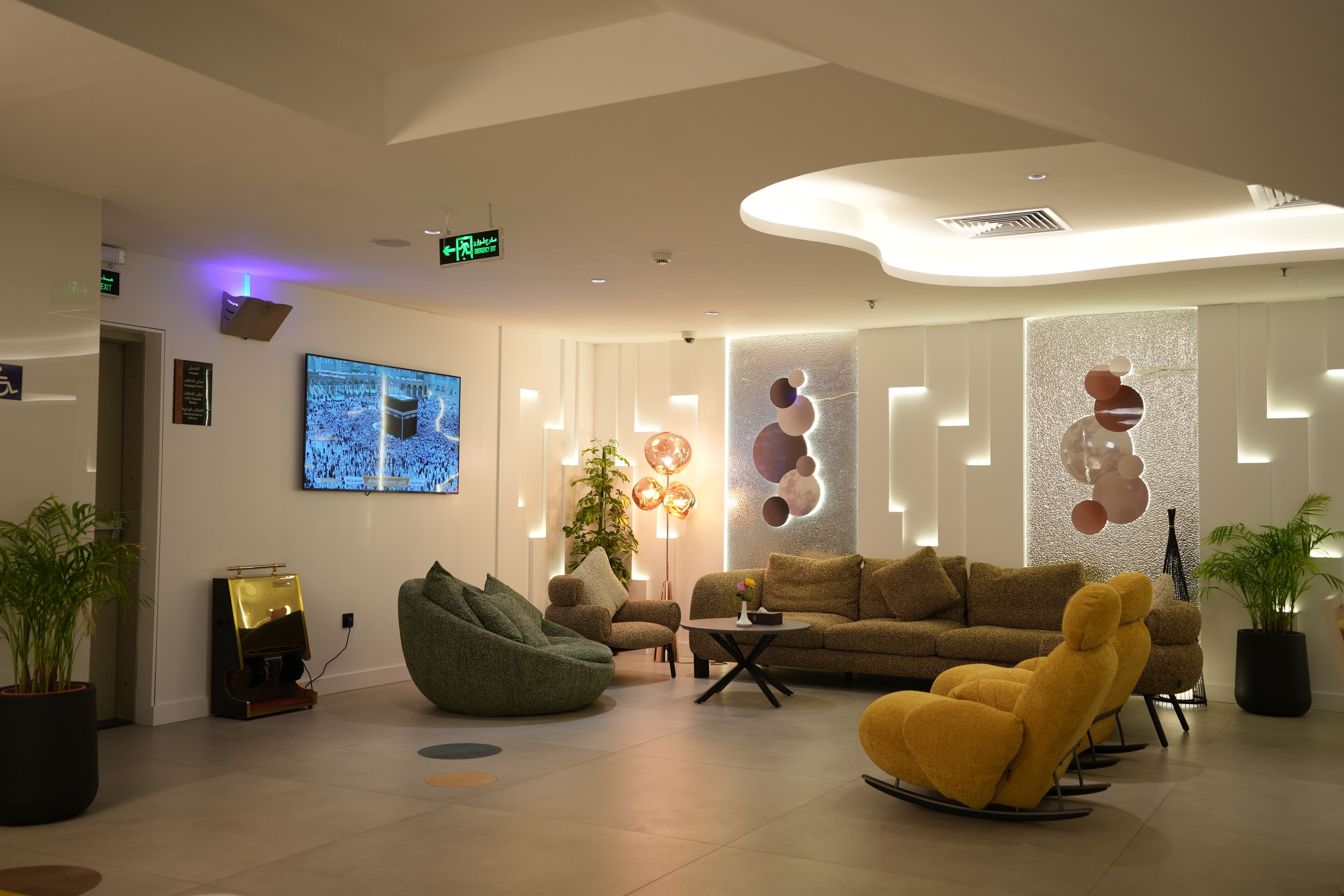 Una hall d'hotel moderna con schermo piatto, posti a sedere confortevoli e decorazioni murali.