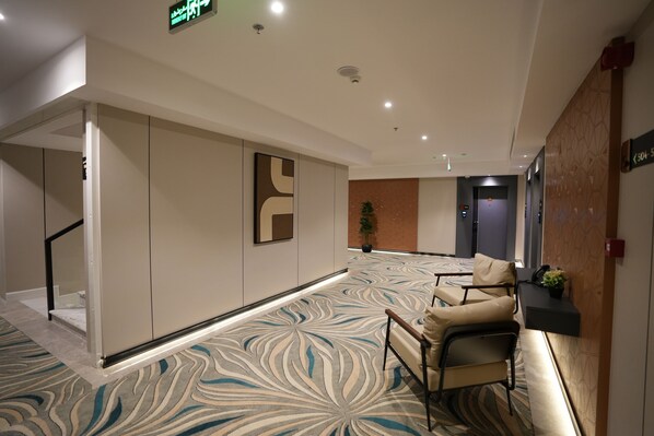 A hotel lobby with a patterned carpet, seating area, and a reception desk. - Casablanca Elite (Jeddah)