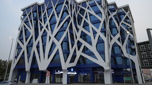 Ein modernes Gebäude mit einer einzigartigen, geometrischen Fassade und großen Fenstern.