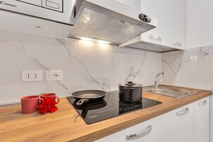 Una cucina moderna con piano cottura integrato, lavello e forno a microonde.