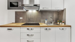 Une cuisine moderne équipée d’un four à micro-ondes, d’une cuisinière et d’un évier intégrés.