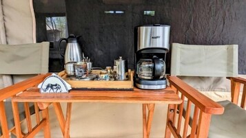 Una mesa de madera con una cafetera, un hervidor y varios recipientes.