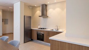 Eine moderne Küche mit Einbauofen, Edelstahl-Kühlschrank und Gasherd.