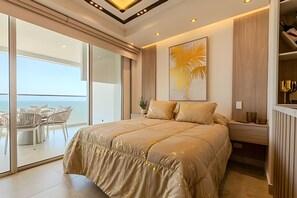 Un dormitorio amplio con una cama grande, un balcón con vistas al mar y una decoración interior moderna.