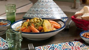 A traditional Moroccan tagine with vegetables, a couscous dish, and bread on a table. - A Thousand and One Nights (Tours)