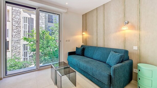 A modern living room with a teal sofa, a glass coffee table, and a green side table. - N&J - JULIANA EMERAUDE - Central Nice • AC • Walk to beach (Niza)