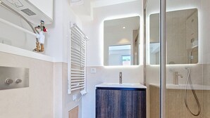 Un baño moderno con ducha, lavabo e inodoro.