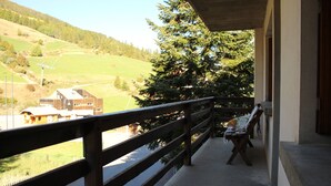 A balcony with a wooden railing overlooking a green valley and a large tree. - Family apartment for 6 people in a quiet residence in Sainte Marie (Vars)