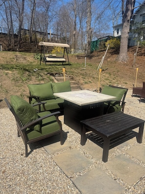 An outdoor patio area with a table and chairs, a swing set, and a garden. - Spacious 4-bedroom apartment in brilliant Bristol with AC (Bristol)