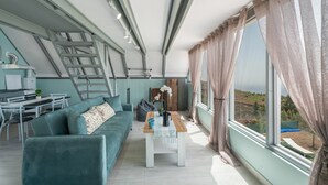 A modern living room with a sofa, coffee table, and a view of the outdoors.