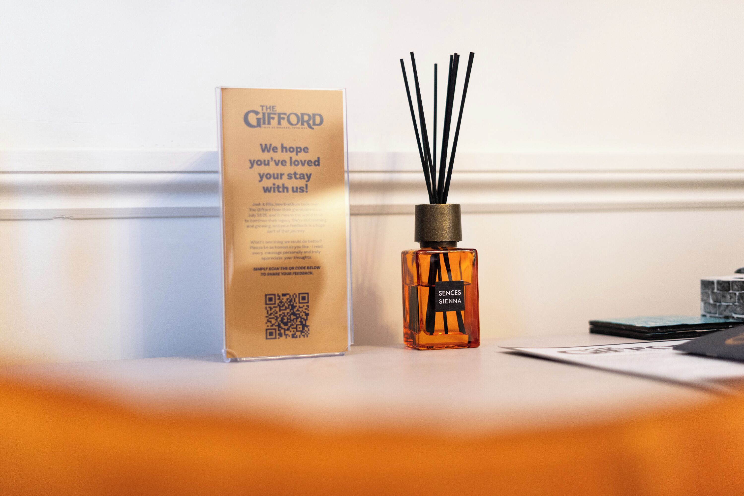 A box and a bottle of Sences Sienna cologne on a table.