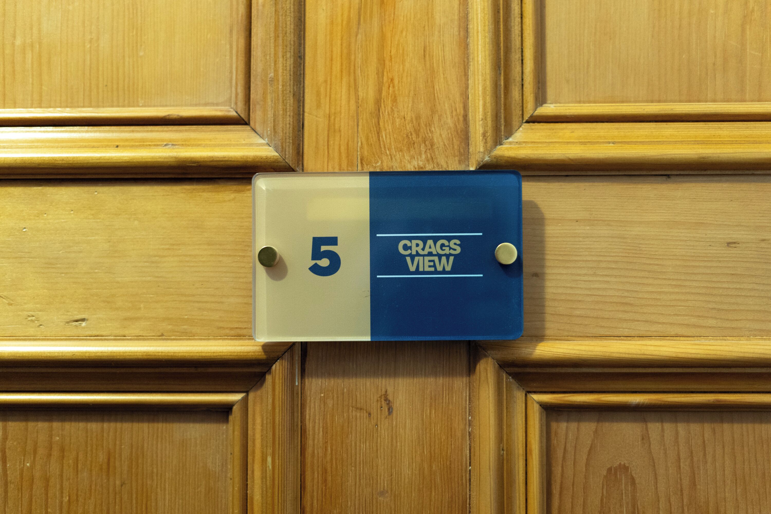 Una puerta de madera con un letrero que dice '5 CRAGS VIEW'.