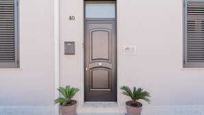 A door with the number 40, a mailbox, and two potted plants.