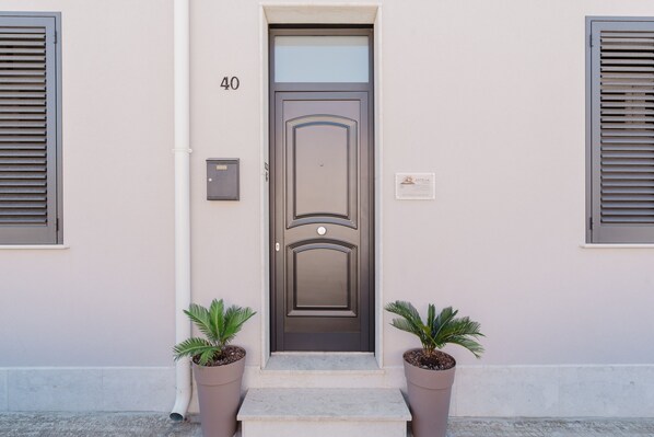 A door with the number 40, a mailbox, and two potted plants.