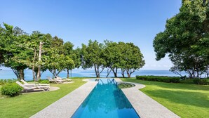 A rectangular pool with a clear blue water surface, surrounded by a gravel path and bordered by well-maintained grass. - CLIFF HOUSE at LILI CLIFF (Ferrol)