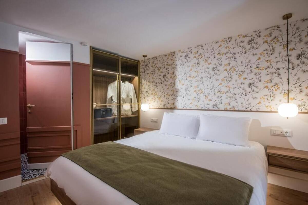 Un dormitorio con cama, armario y espejo.