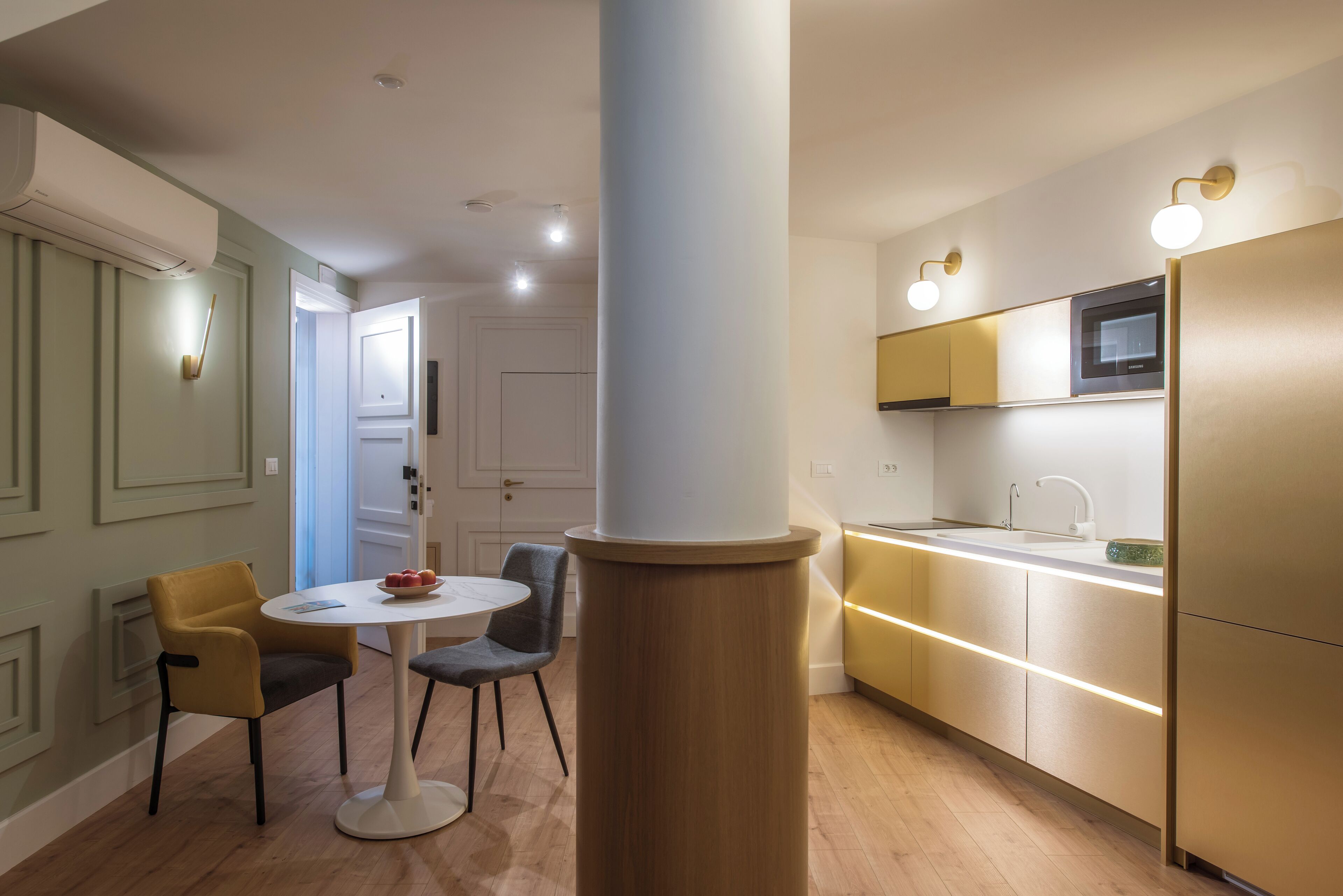 A modern kitchen with a central island, built-in microwave, and under-cabinet lighting.