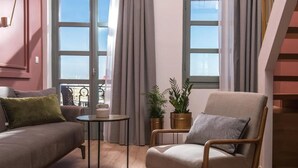 Una sala de estar moderna con sofá, sillón, una mesita y plantas en macetas.