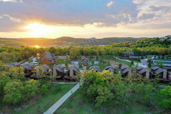 A resort with multiple cabins, a central pool, and a scenic sunset view.