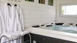 Ein Spa-Raum mit Whirlpool, weißen Handtüchern und Bambus-Wandverkleidung.