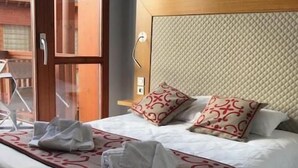 Ein Hotelzimmer mit Bett, Fenster und Tür.