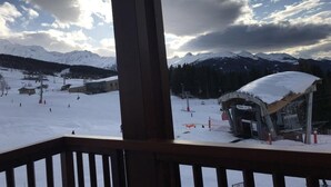 Ein Skigebiet mit verschneiter Landschaft, einer Seilbahn und einem Gebäude mit schneebedecktem Dach.