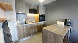 Une cuisine moderne avec des meubles en bois, un four encastré et un îlot central.