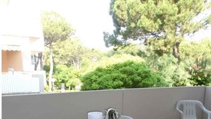 A balcony with a table and chairs, a metal kettle, and a pitcher. - Holiday apartment mit Balkon (Bibione)