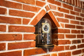 A brick wall with a clock embedded in a brick archway.