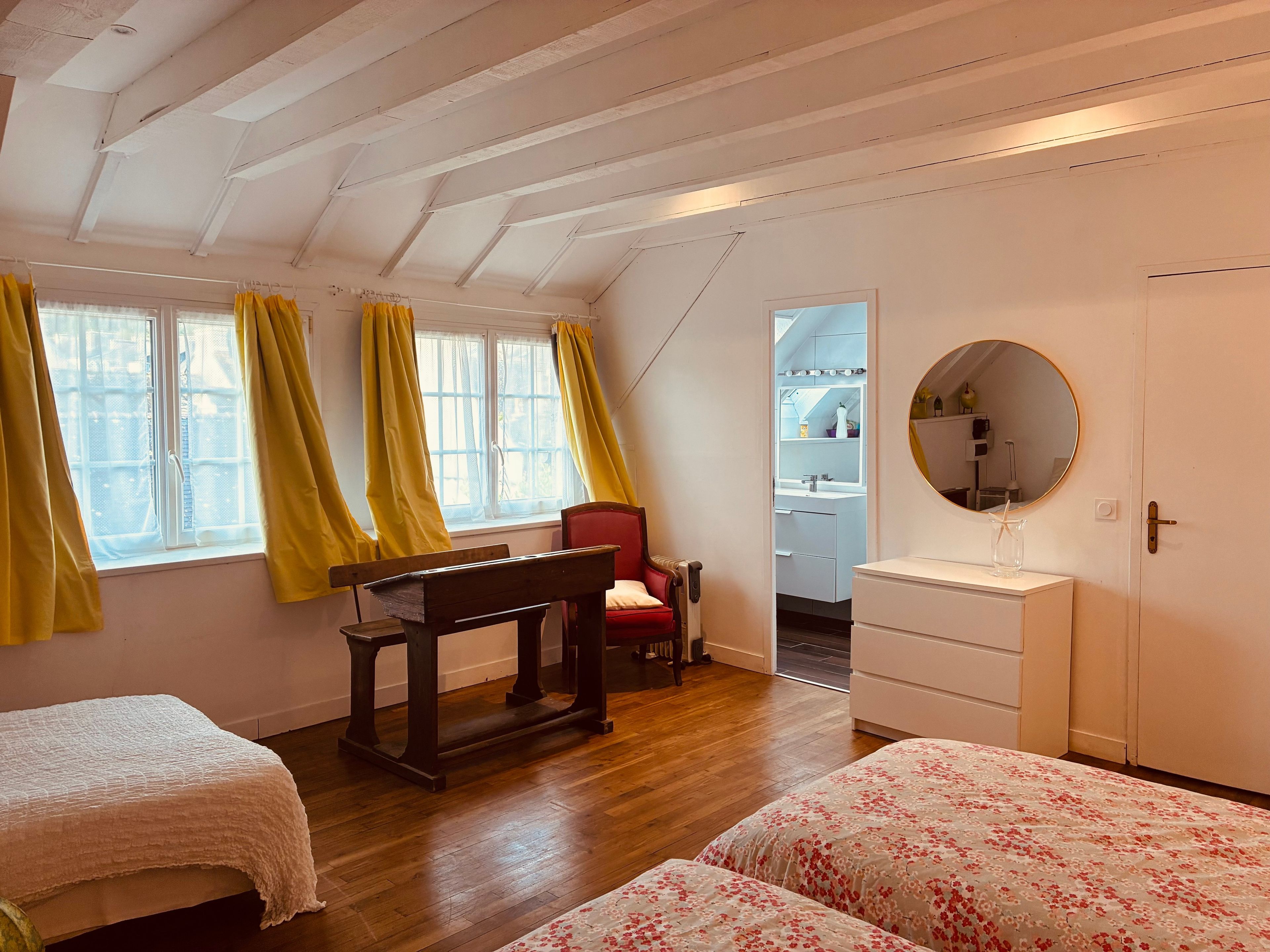 Ein Schlafzimmer mit zwei Betten, einem Schreibtisch, einem Stuhl, einer Kommode und einem Kleiderschrank.