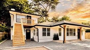 A two-story house with a front porch, a wooden staircase, and a gravel driveway. - Welcome to The Pink Peony on Market Street in historic downtown Brenham. (Brenham)