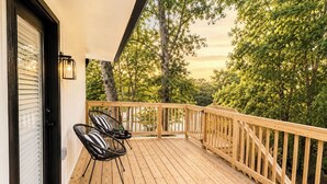 A wooden deck with a railing, two chairs, and a door with blinds. - Welcome to The Pink Peony on Market Street in historic downtown Brenham. (Brenham)