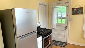 A kitchen with a refrigerator, stove, oven, and a door with a window. - Charming 2-bedroom house in fabulous downtown Hermann (Hermann)